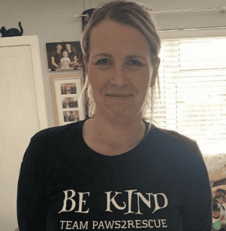 A photo of Paws2Rescue team member Victoria (Vicky) smiling while wearing a sweatshirt with the words "Be Kind" printed on the front